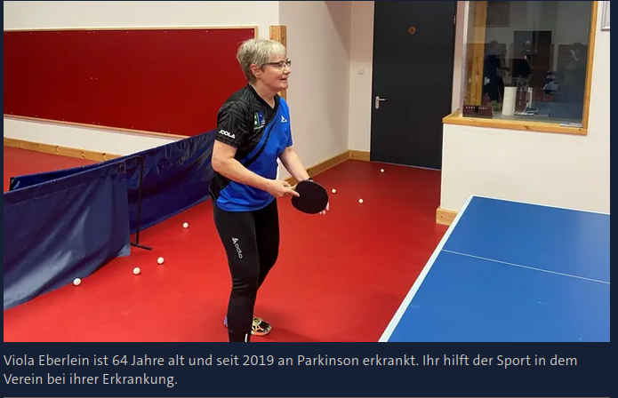 Bild von Viola Eberlein im blau-schwarzen Trikot beim Tischtennis-Spiel: "Viola Eberlein ist 64 Jahre alt und seit 2019 an Parkinson erkrankt. Ihr hilft der Sport in dem Verein bei ihrer Erkrankung."