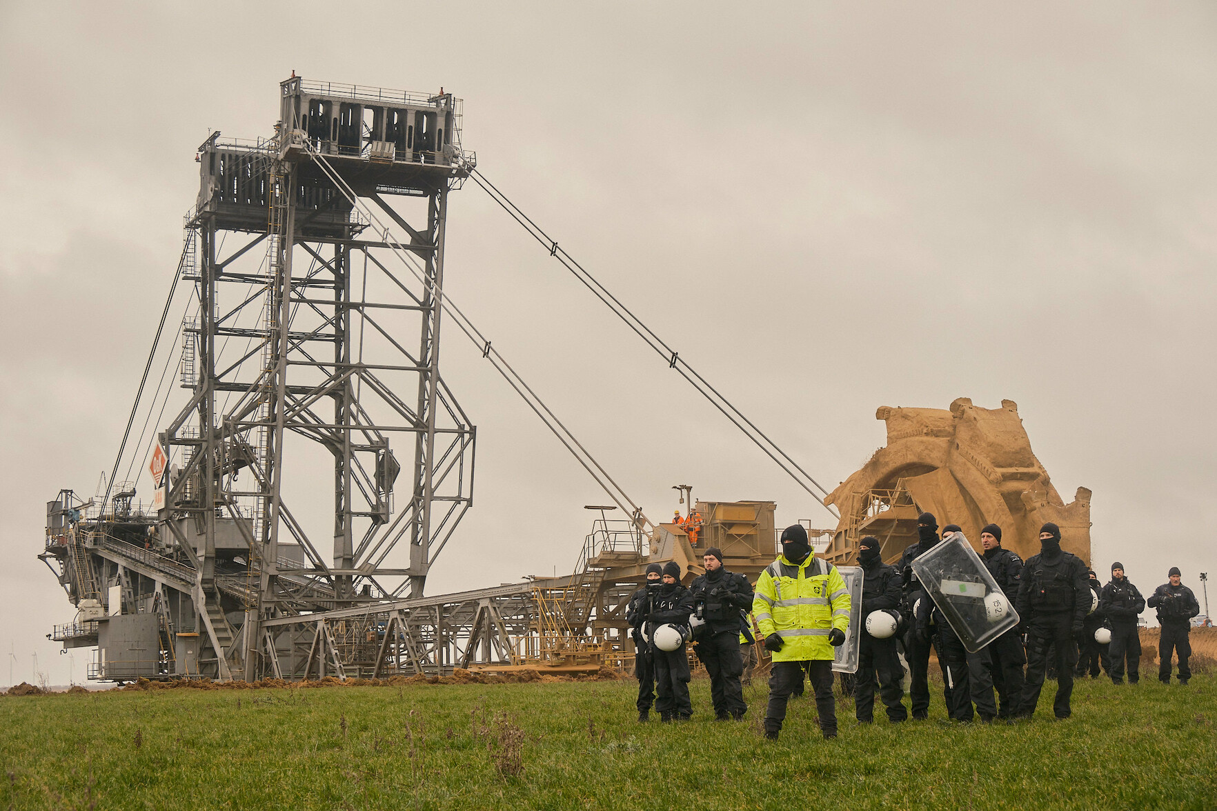 Cops vor Schaufelradbagger am Tagebau Garzweiler nahe Lützerath, Januar 2023.