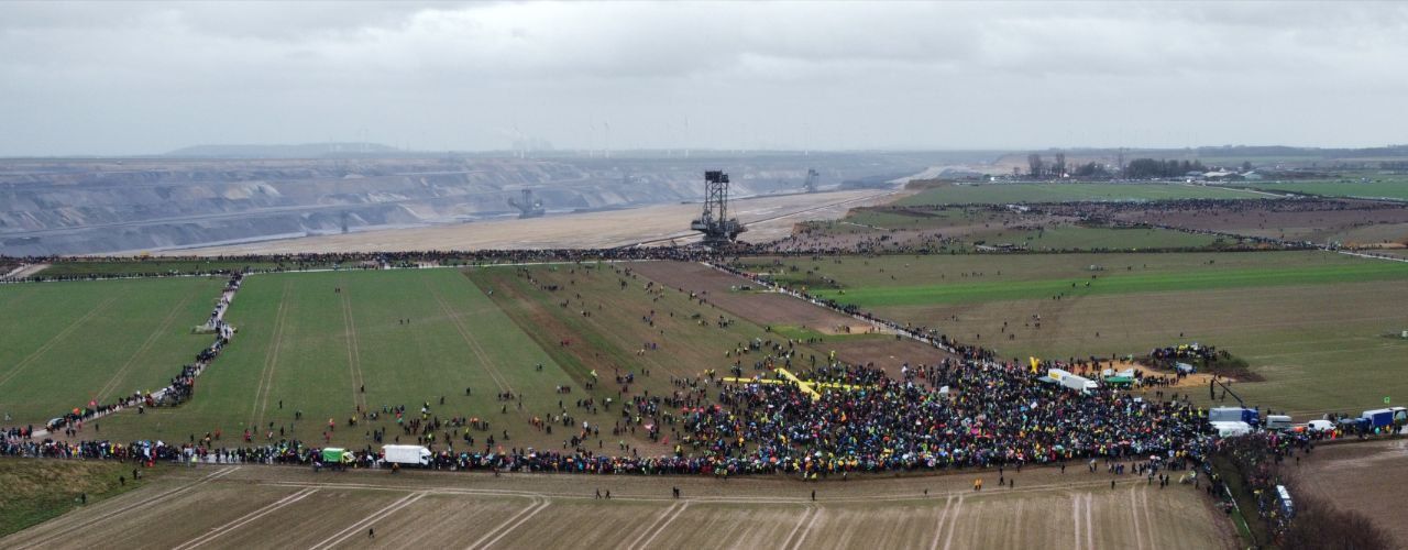 Bild von Lützerath Demo mit Braunkohleschluchten im Hintergrund